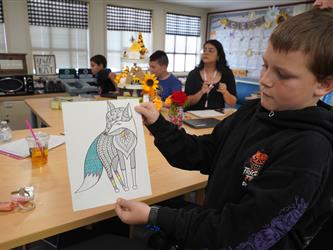 student showing his drawing