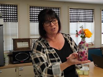 Teacher showing flower in vase