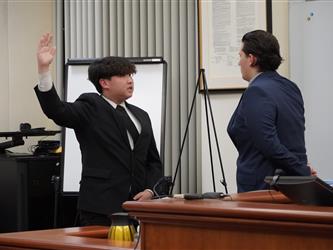 Student participant takes an oath before providing testimony during a mock trial proceeding.